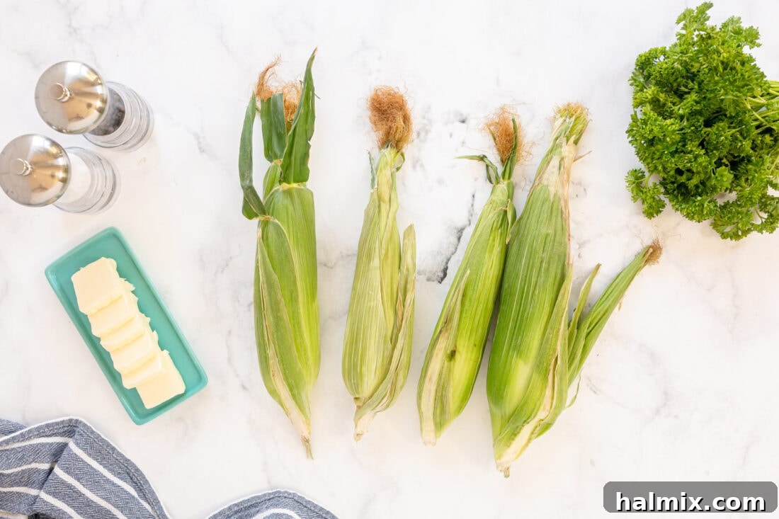 Fresh ingredients for Grilled Corn on the Cob, including corn, butter, and parsley