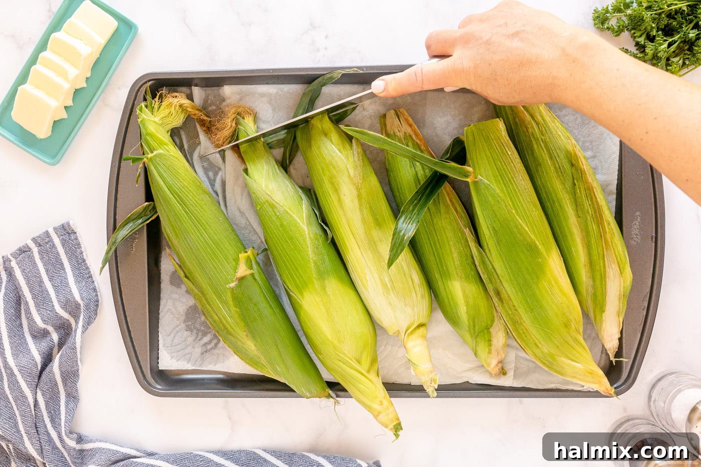 corn drying on a baking sheet with paper towels after soaking