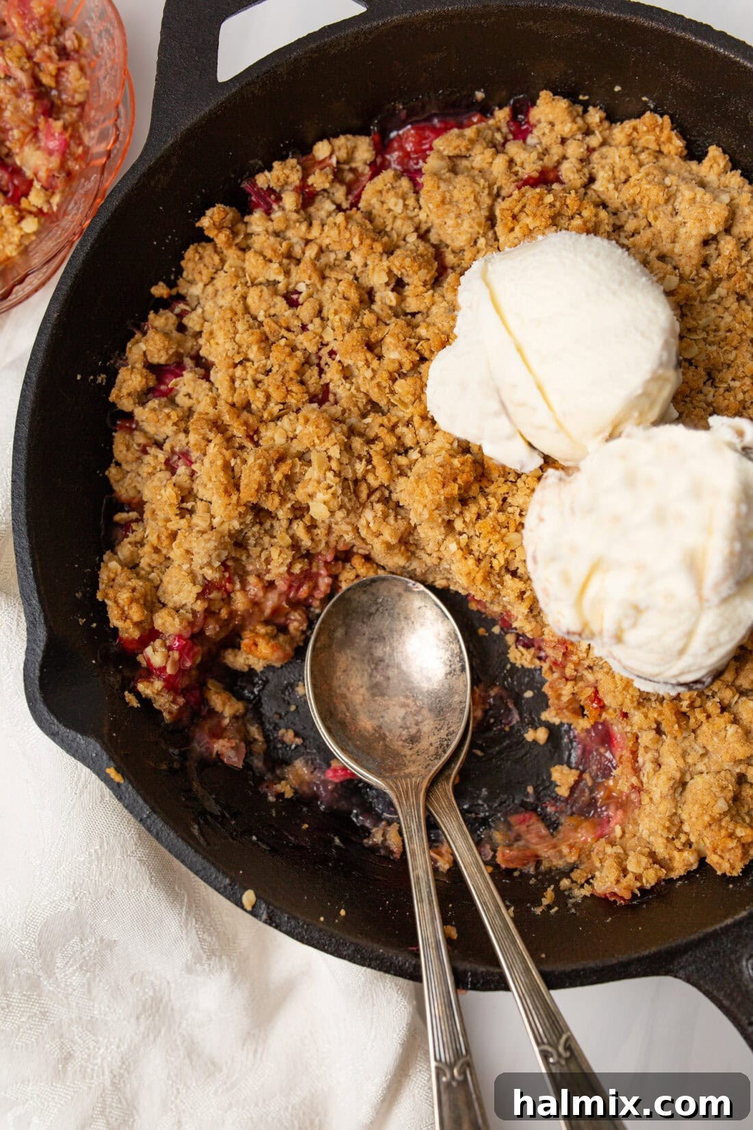 Sweet & Tangy Rhubarb Crunch 3 Freshly baked rhubarb crisp cooling in a cast iron skillet, showcasing its golden-brown topping