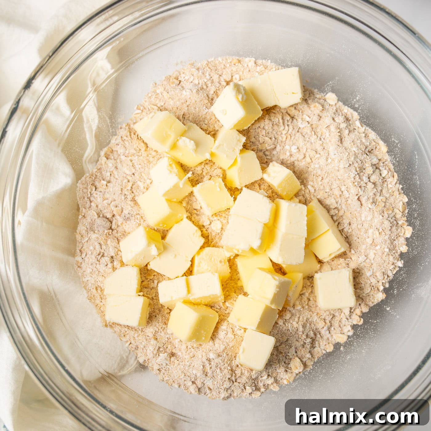 Sweet & Tangy Rhubarb Crunch 6 A bowl containing a flour mixture with cubes of cold butter, ready to be blended for the crisp topping