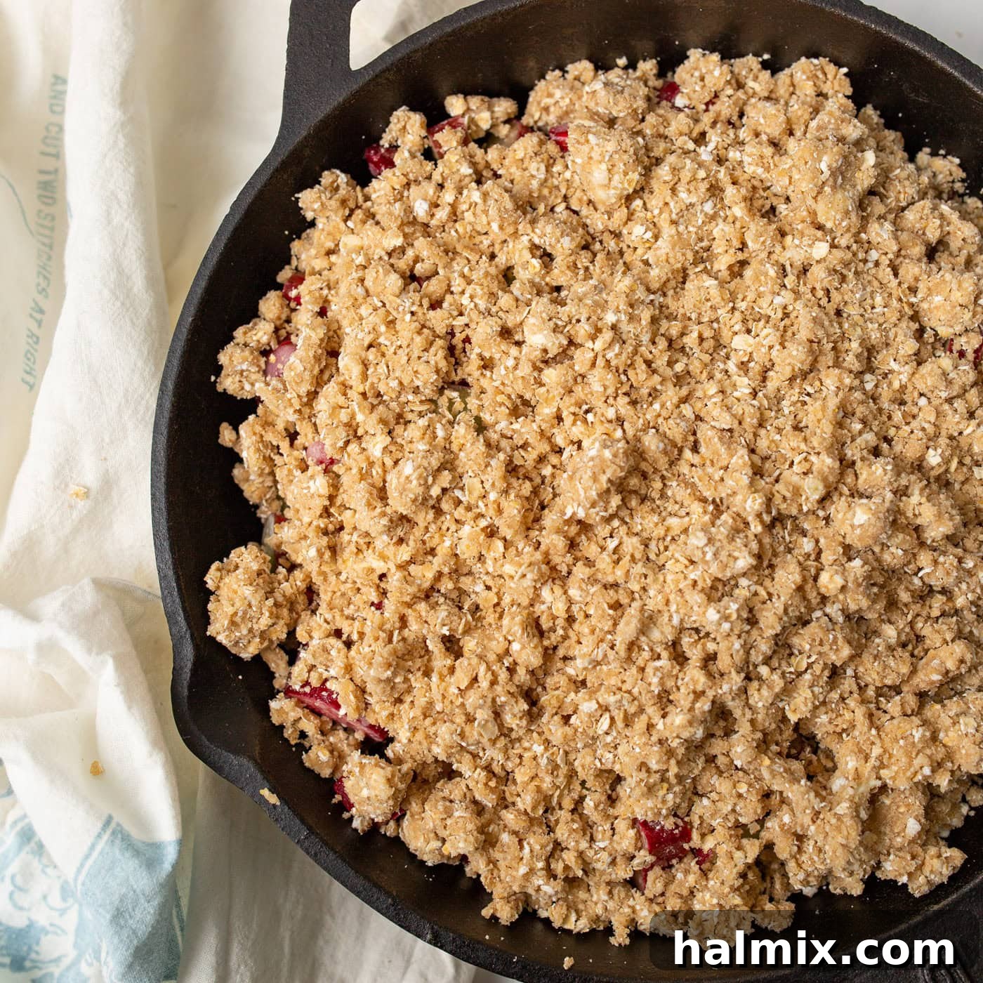 Sweet & Tangy Rhubarb Crunch 7 A cast iron skillet filled with a freshly baked rhubarb crisp, featuring a perfectly browned, crunchy topping