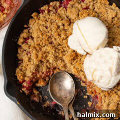 Close up photo of Rhubarb Crisp in a skillet topped with ice cream