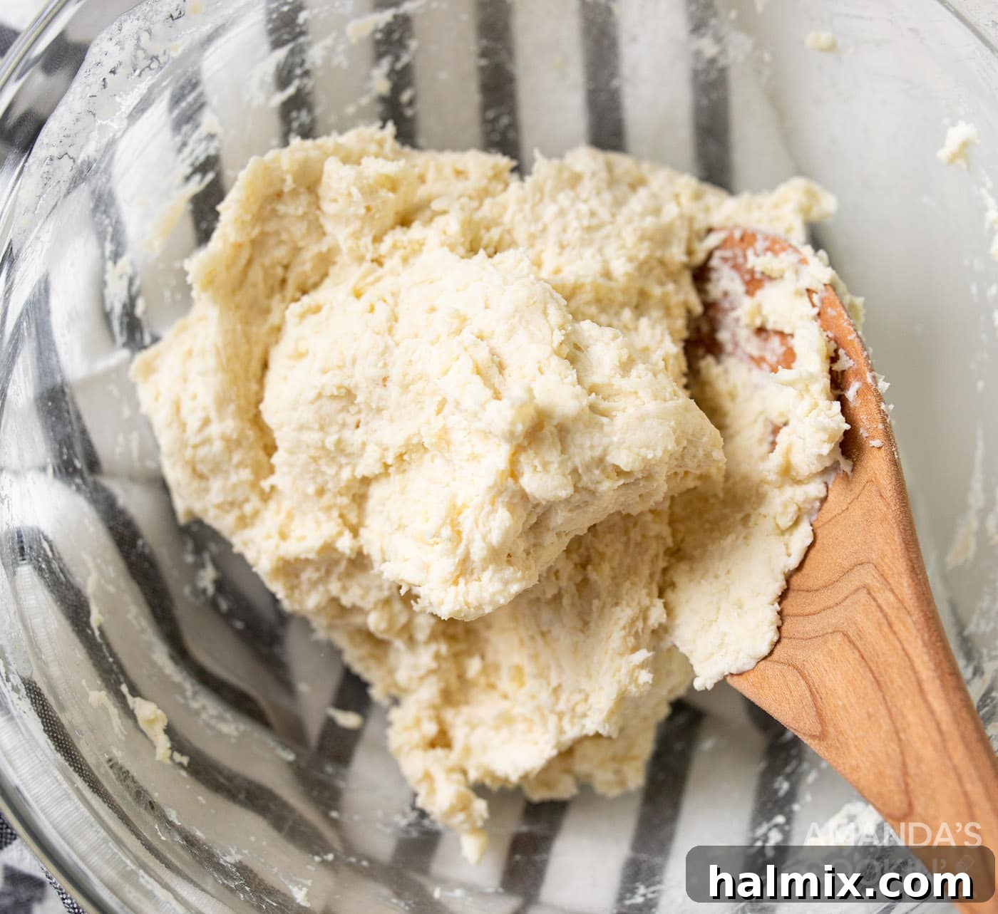 Pie dough being mixed in a bowl with a wooden spoon