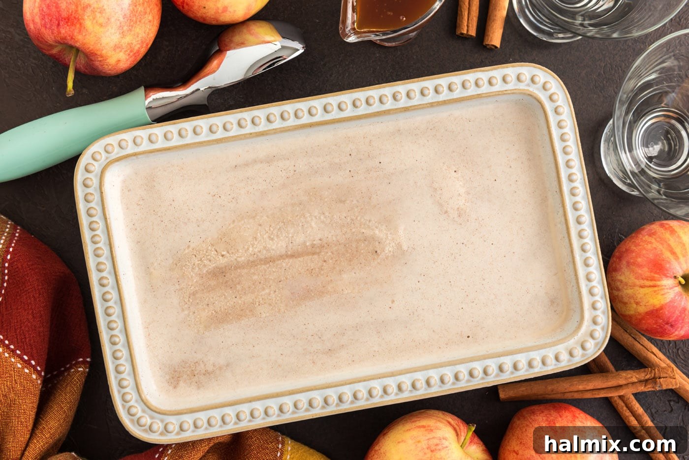 Freshly churned apple cider ice cream, now thick and creamy, carefully transferred into a metallic loaf pan, ready to be placed in the freezer for final hardening.