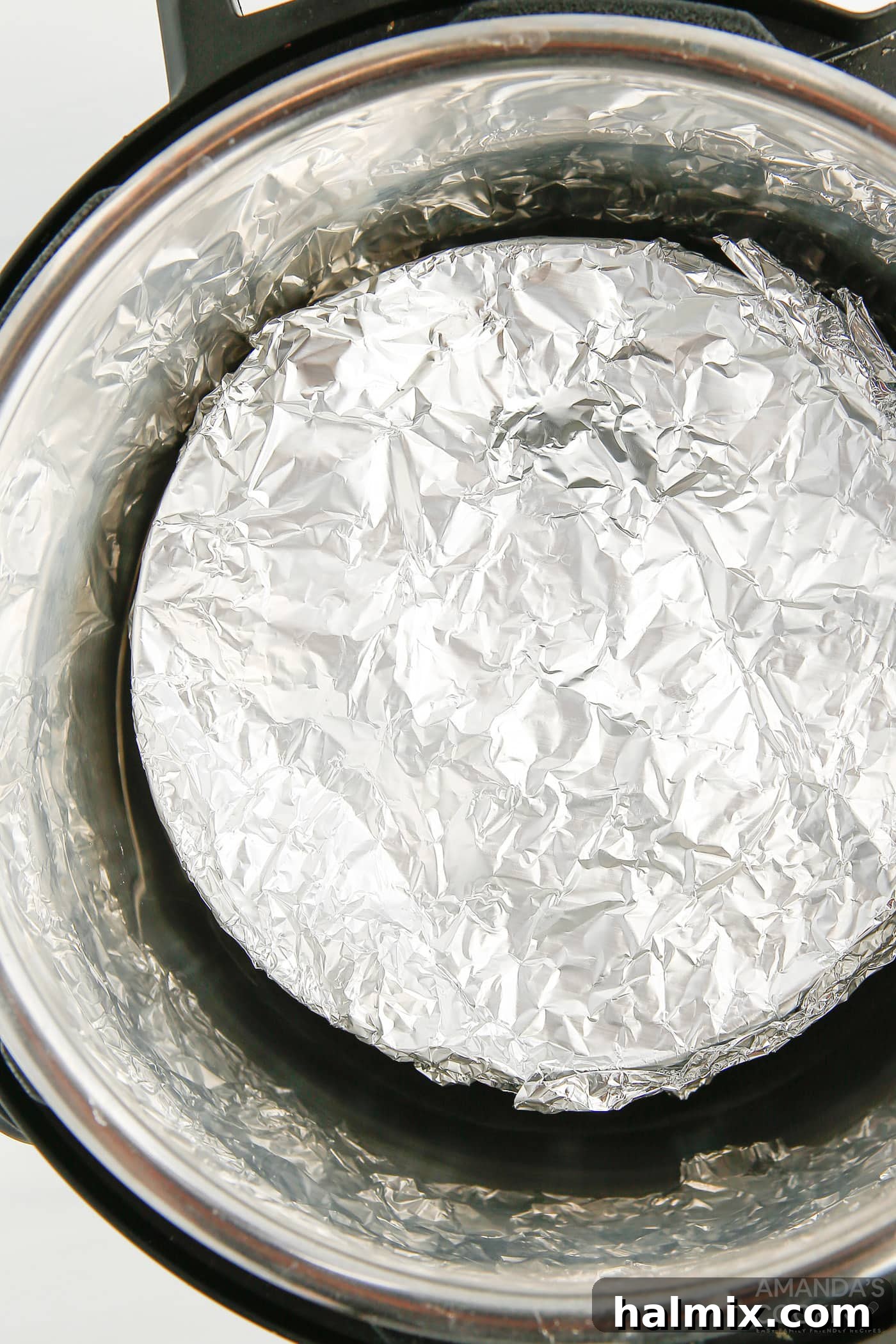 springform pan covered in aluminum foil in an instant pot