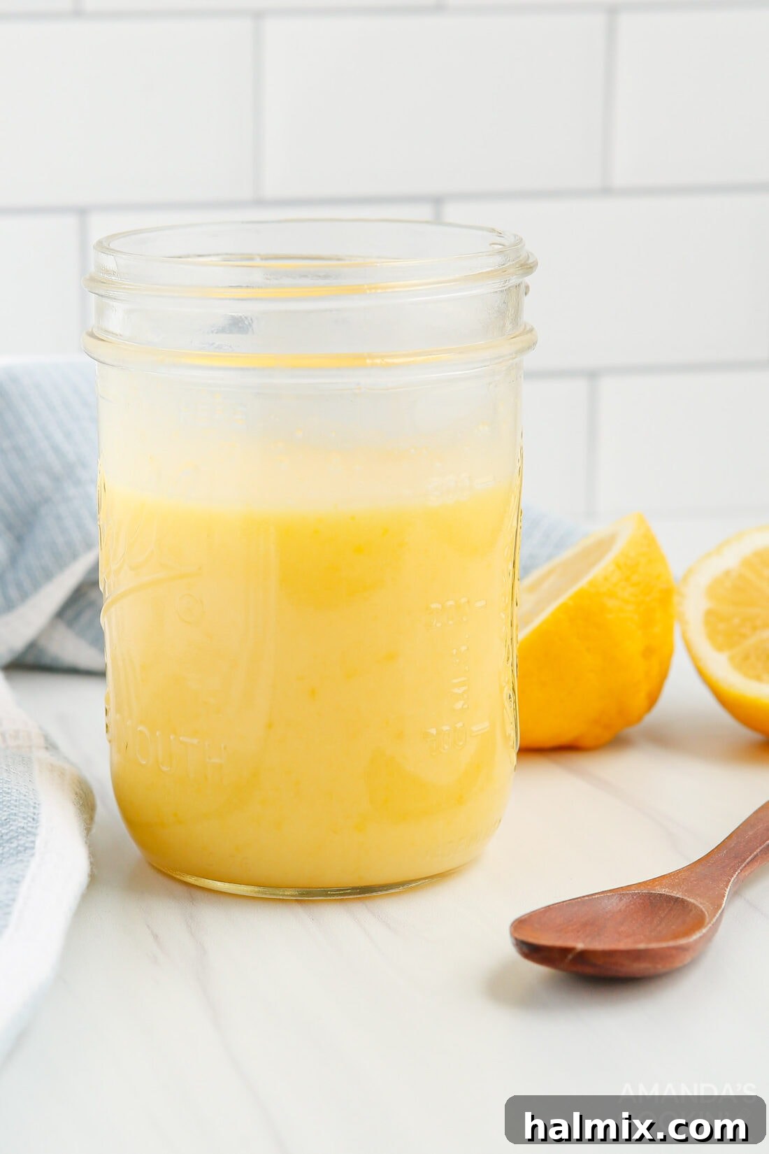 close up of jar of lemon curd with a spoon