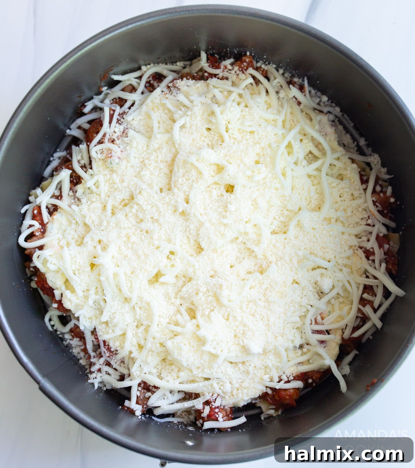 Effortless Instant Pot Lasagna 11 A generous sprinkling of mozzarella and Parmesan cheeses over the ricotta layer, preparing for the next set of layers.
