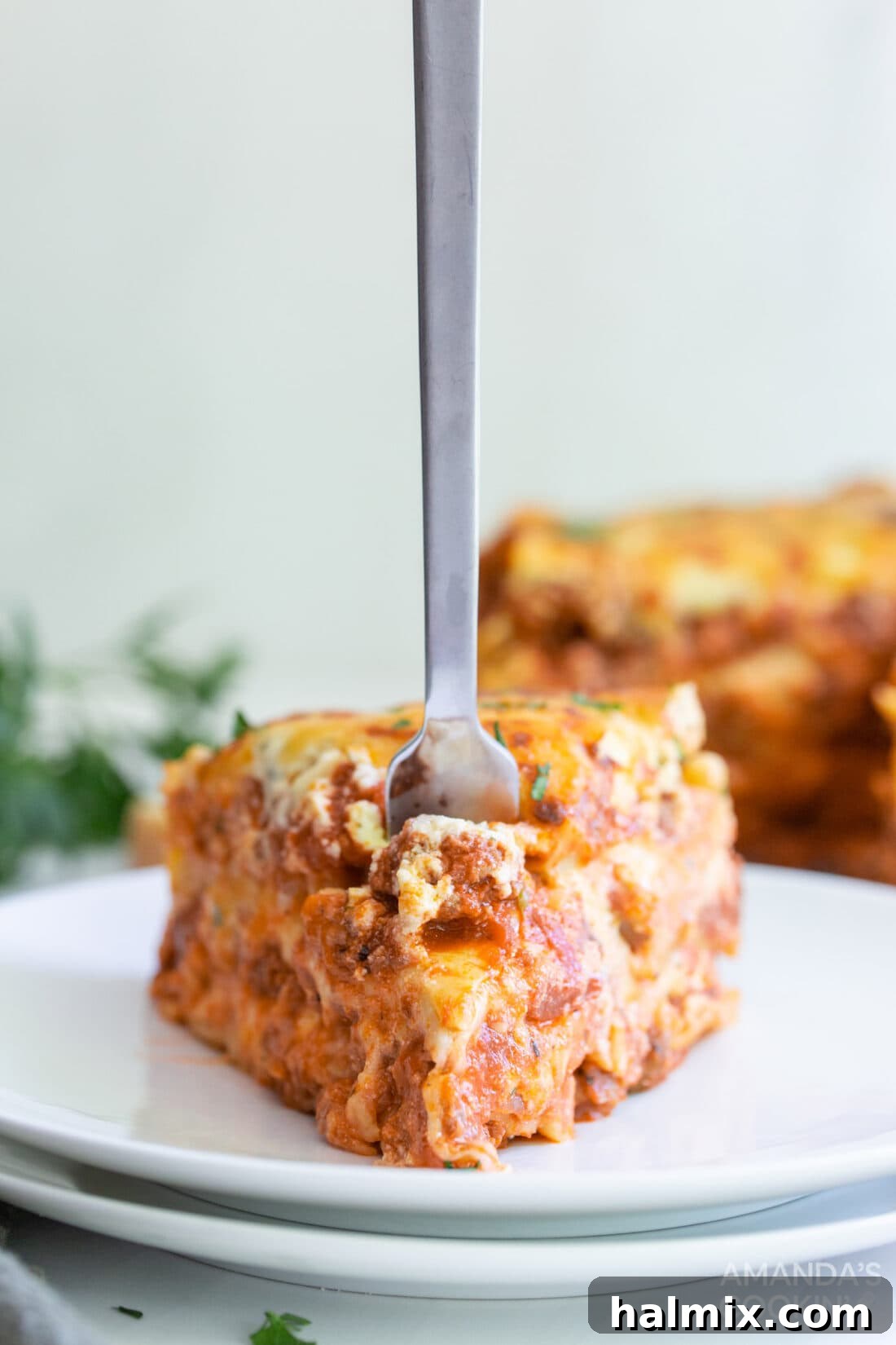 Effortless Instant Pot Lasagna 14 A fork piercing a perfect, gooey slice of Instant Pot Lasagna, showcasing the rich layers of meat, cheese, and pasta.