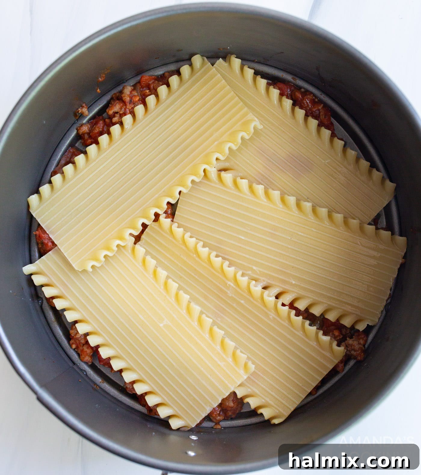 Effortless Instant Pot Lasagna 9 The first layer of lasagna noodles carefully placed over the meat sauce in the springform pan.