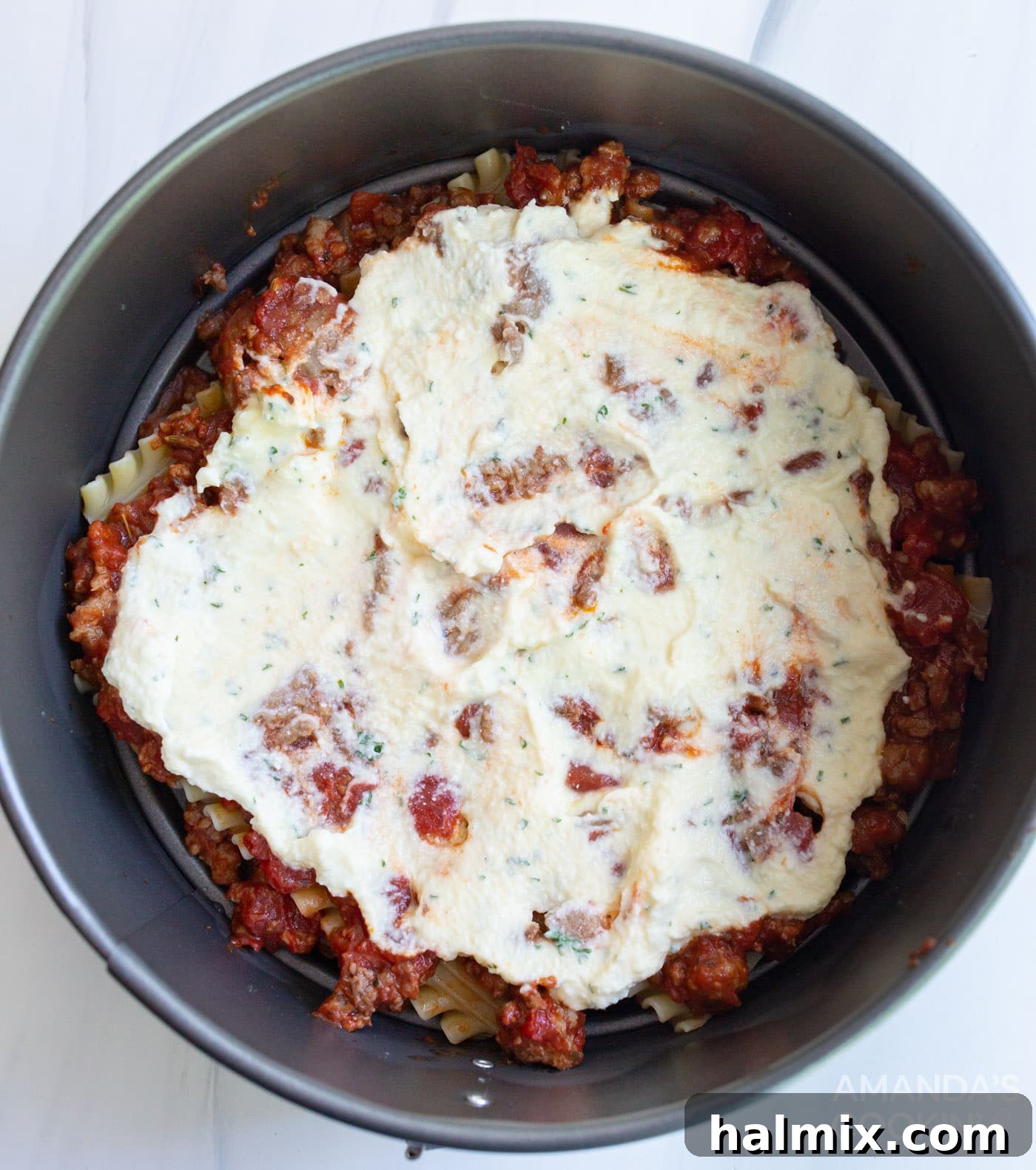 Effortless Instant Pot Lasagna 10 A creamy layer of ricotta mixture generously spread over the lasagna noodles and meat sauce in the pan.