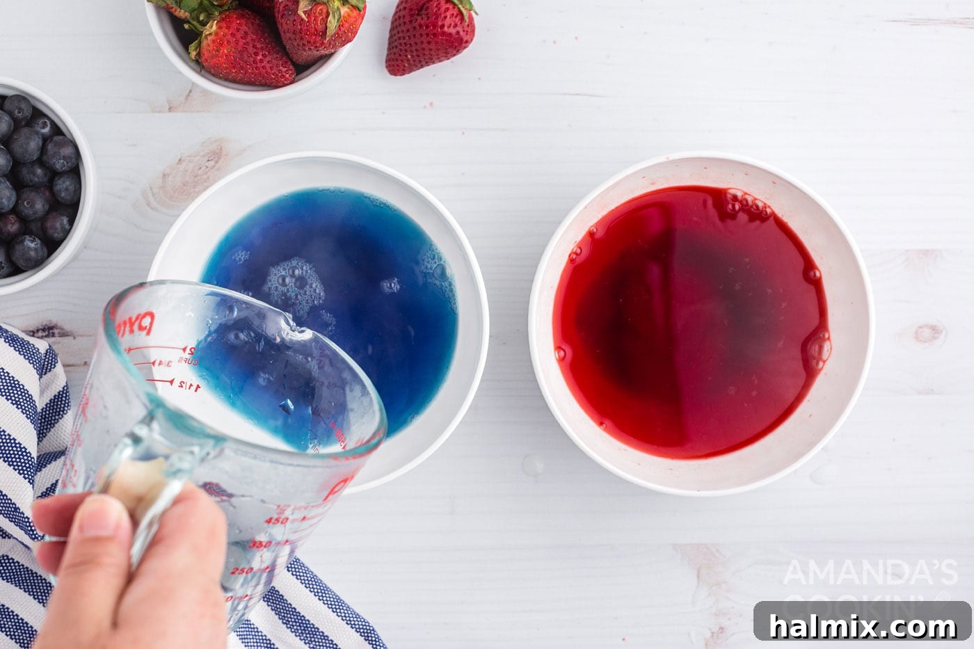 Two bowls, one with red Jell-O mixture and one with blue Jell-O mixture, being prepared with water.