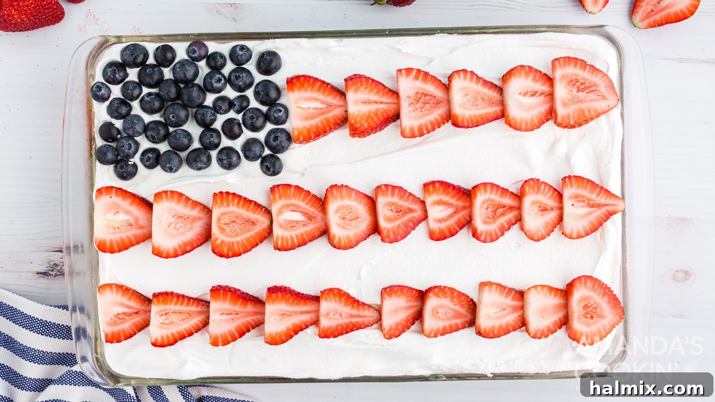 The finished cake decorated like an American flag with blueberries and strawberry slices.