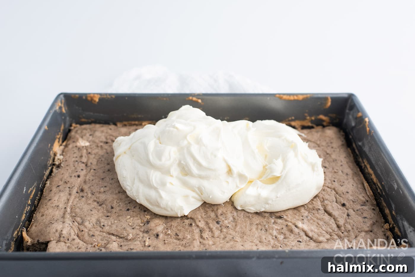 Smooth cheesecake layer spread over the cooled Oreo cake