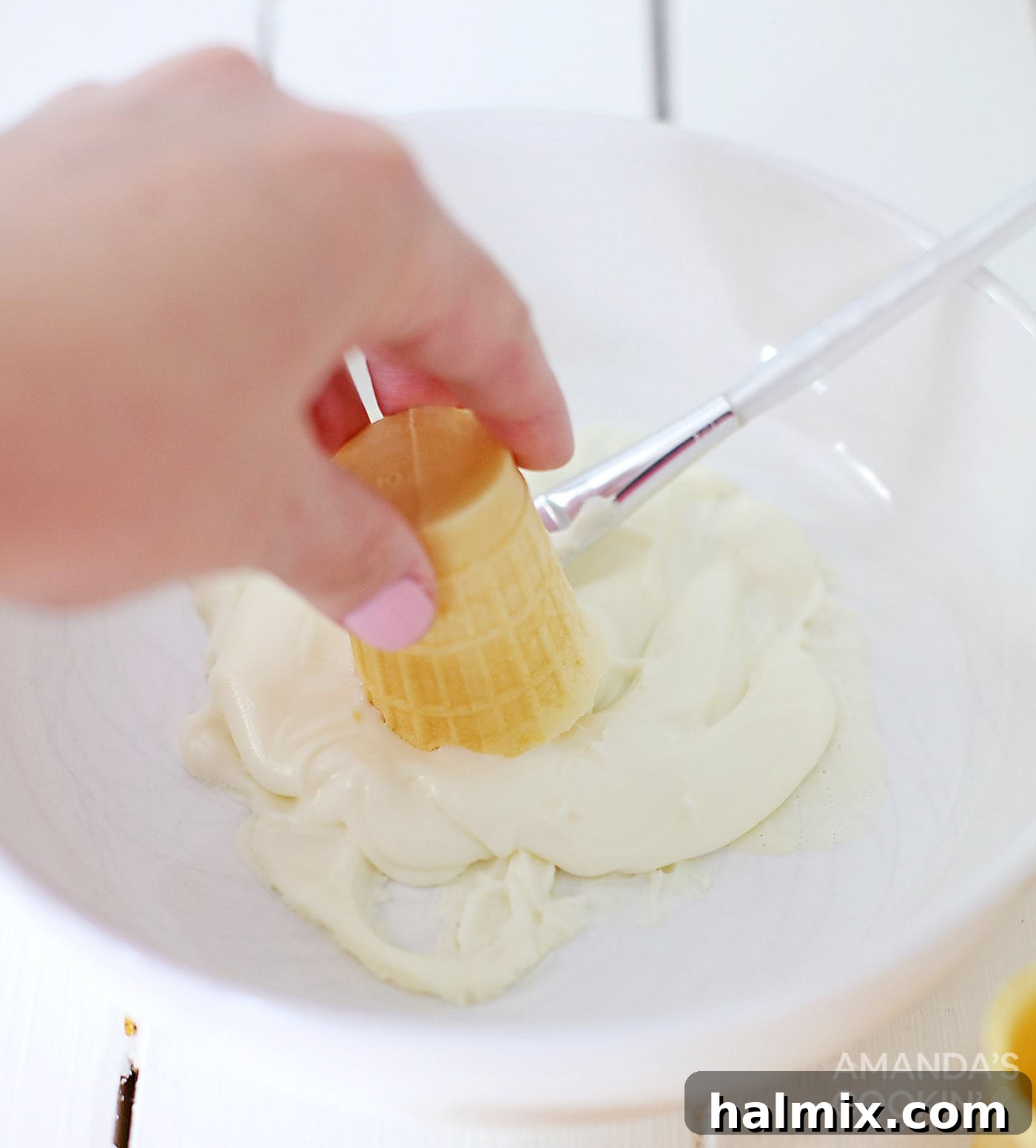 Dipping ice cream cone in white chocolate for Rum Chata Shots