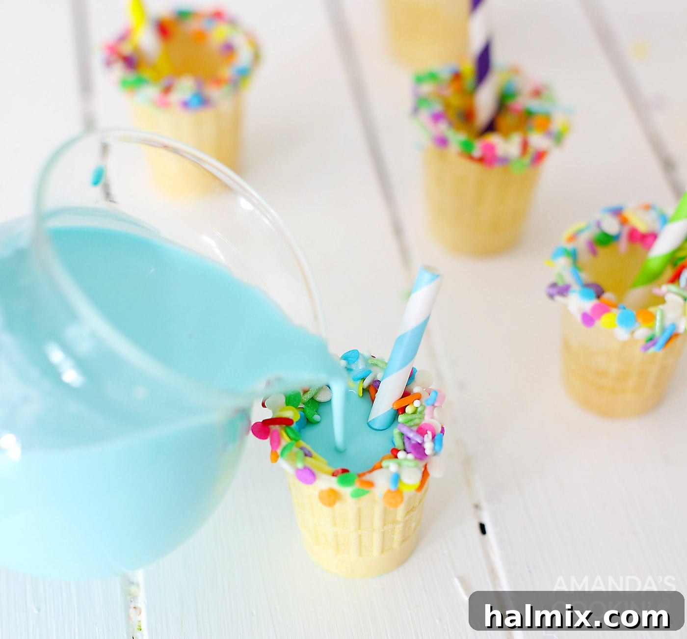 Pouring blue rum chata into ice cream cone shot glasses