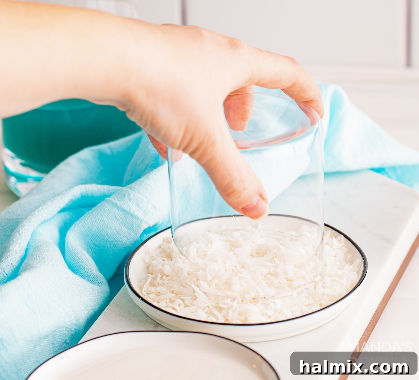 Neptune's Kiss Cocktail 5 Dipping the rim of a glass into flaked sweetened coconut to create a tropical garnish for the Ocean Water Cocktail.
