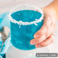 Neptune's Kiss Cocktail 10 holding a glass of Ocean Water Cocktail