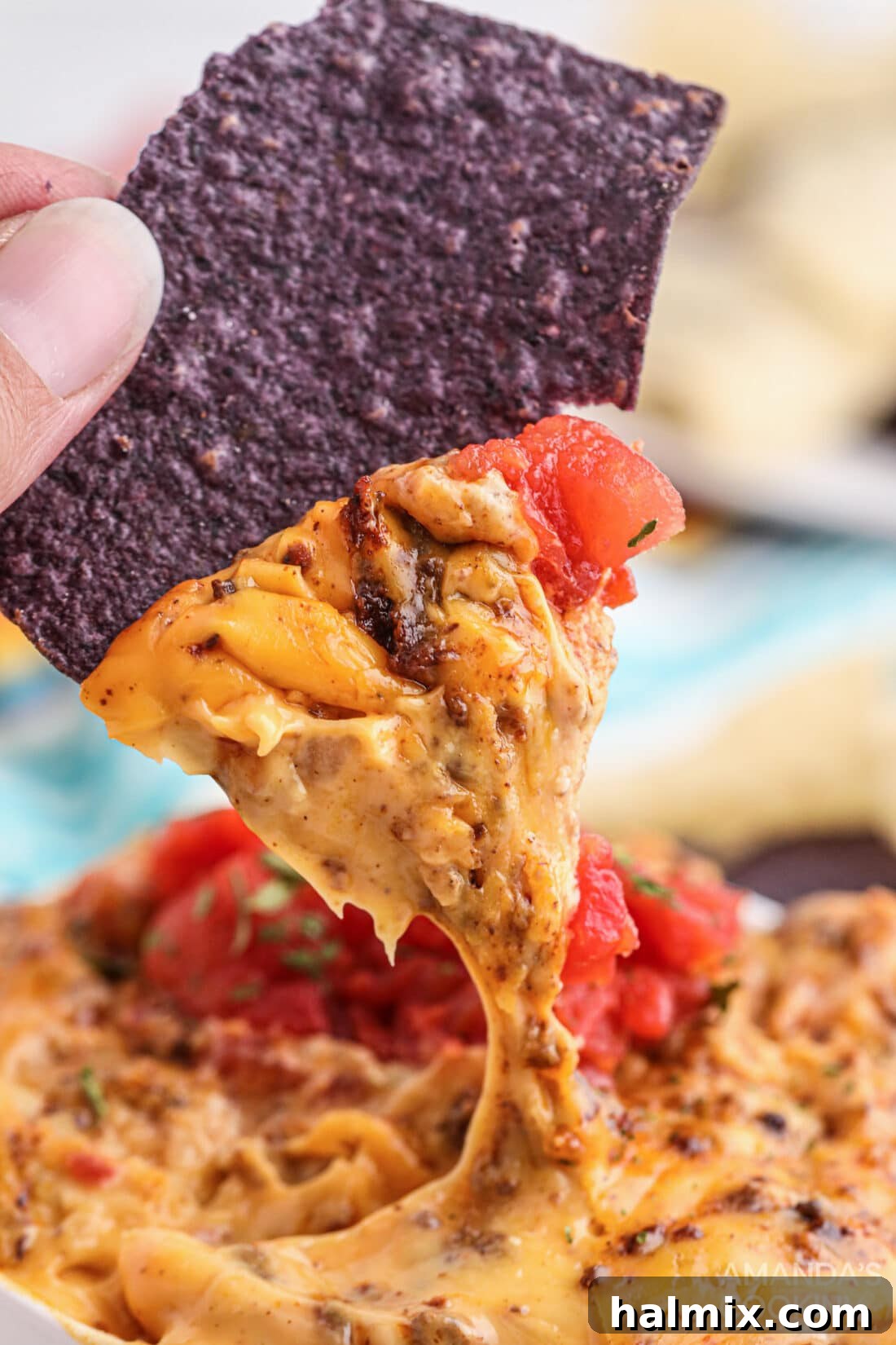 Smoky Cheese Dip 7 dipping chip into Smoked Queso Dip