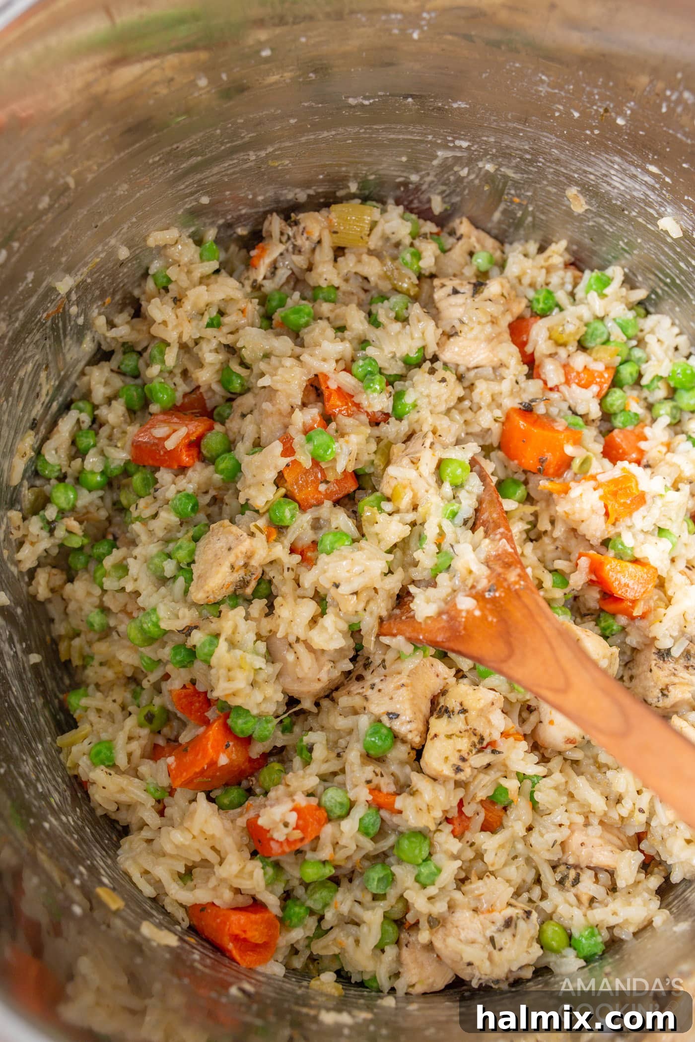 Easy Instant Pot Chicken and Rice 9 The final step of gently stirring the cooked chicken and rice in the Instant Pot, showcasing its fluffy texture.