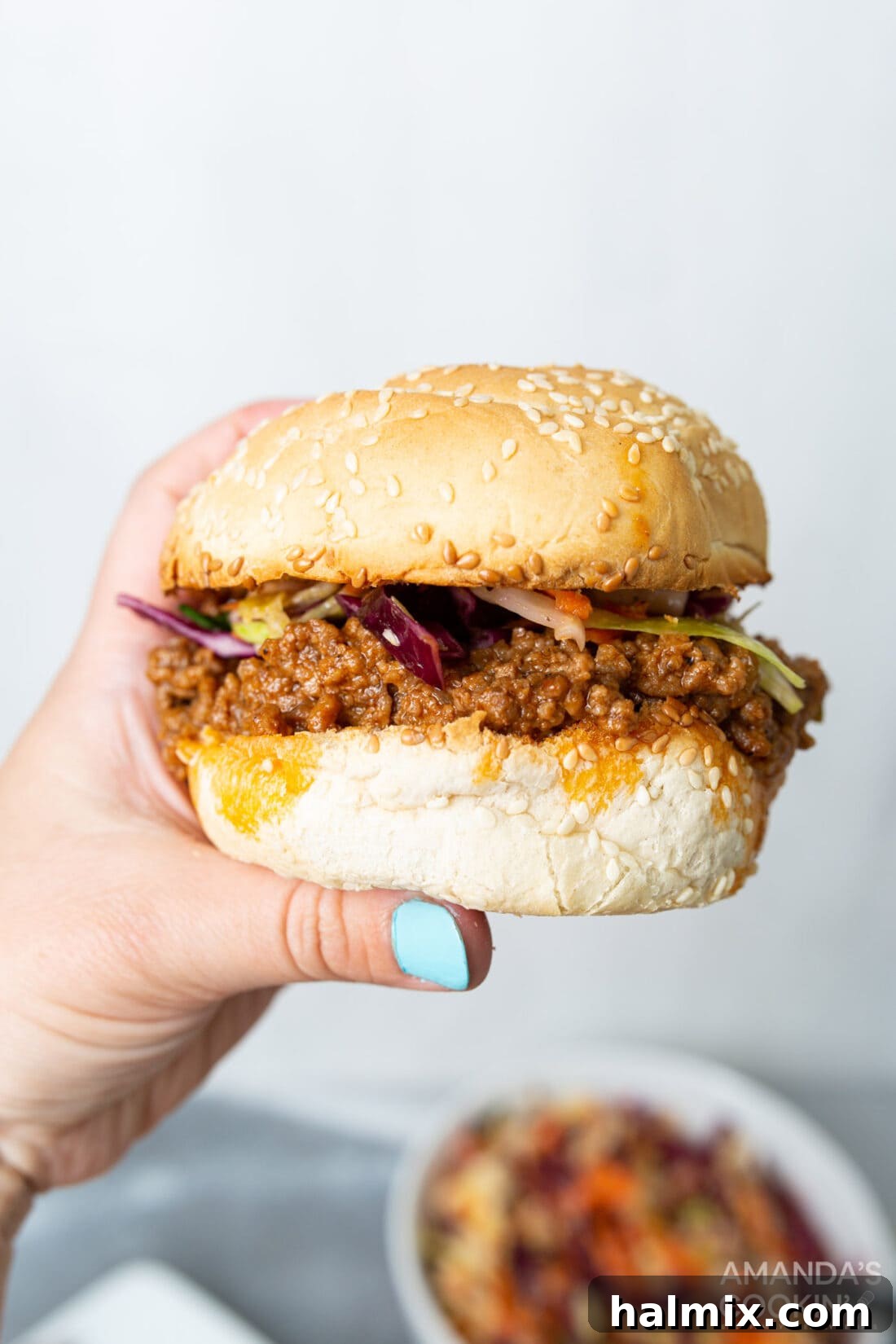 Lightning-Fast Instant Pot Sloppy Joes 3 holding a sloppy joe sandwich, showcasing the delicious and hearty filling