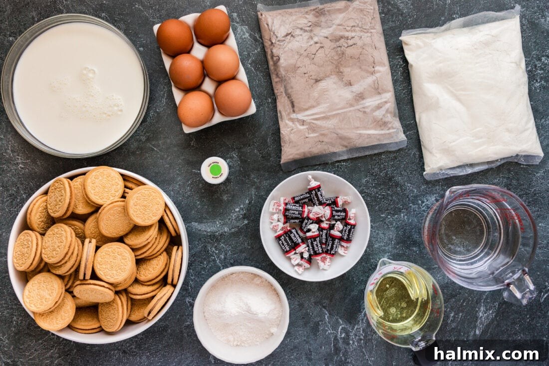 Various ingredients laid out for making Kitty Litter Cake, including cake mixes, cookies, pudding, and Tootsie Rolls.