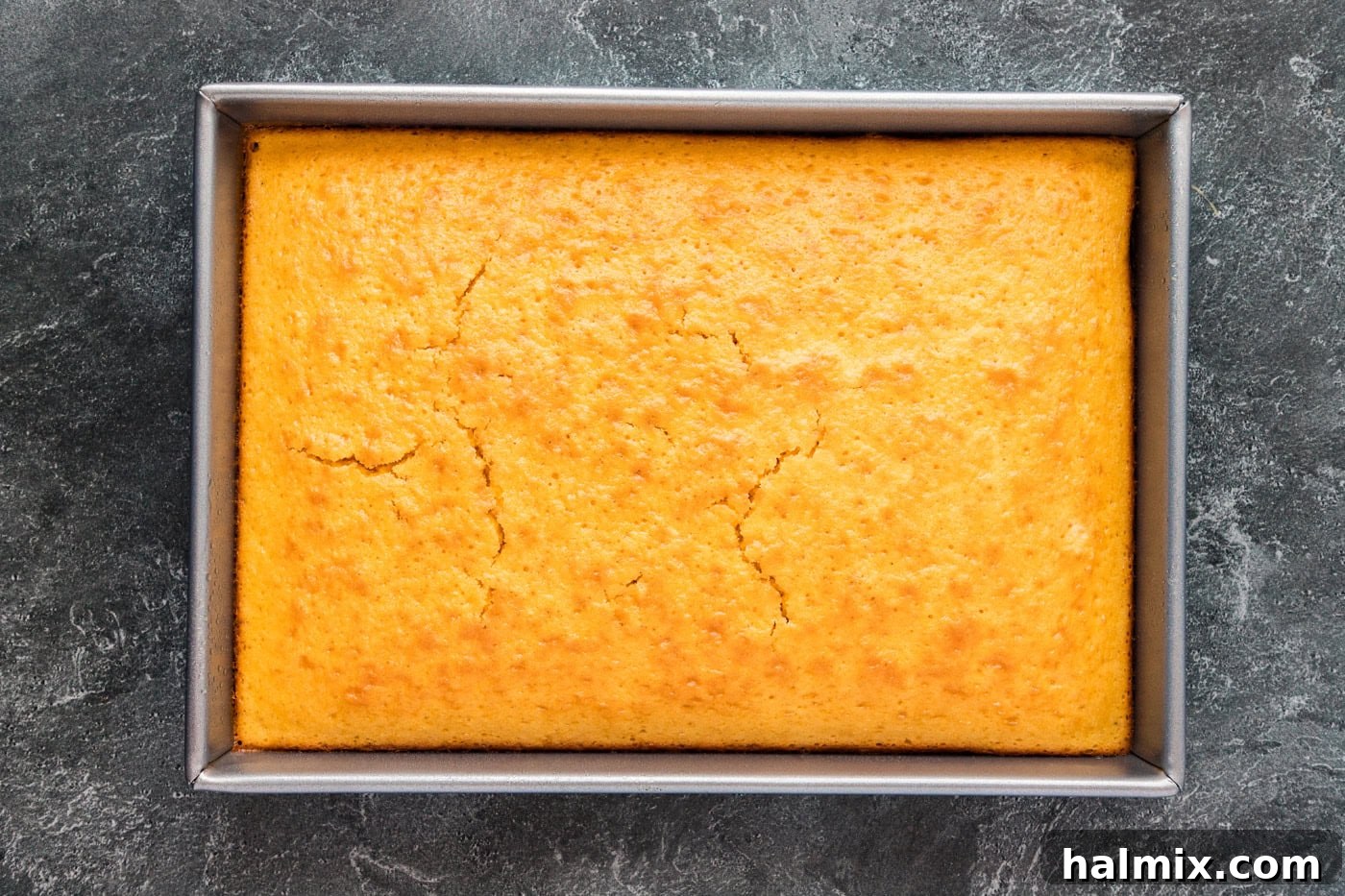 A baked yellow cake resting in a dish, ready for crumbling.