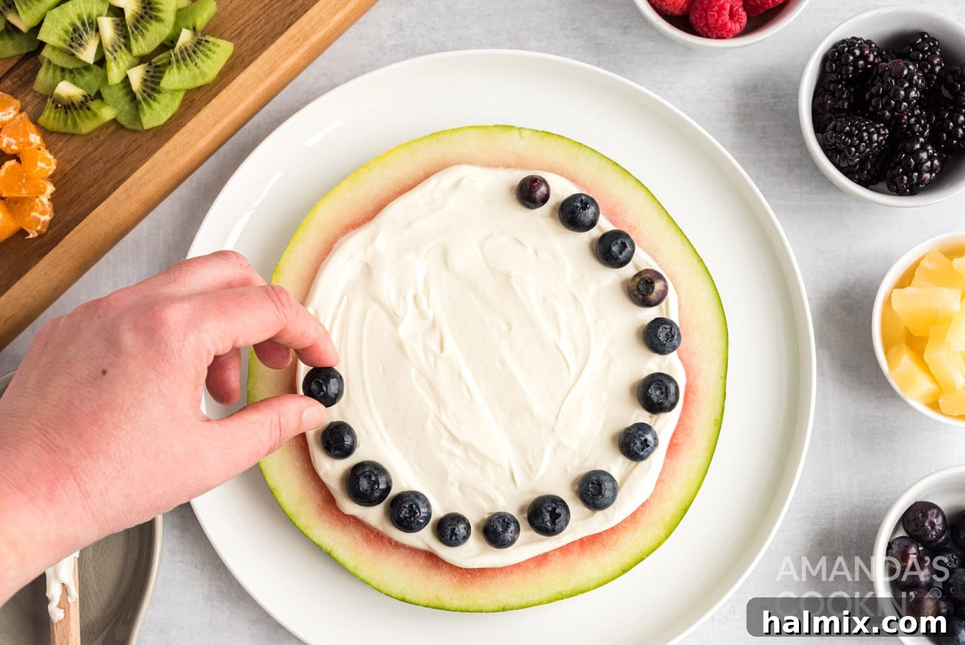 Crimson Crust Pizza 11 hand placing blueberries around the edge of a watermelon slice