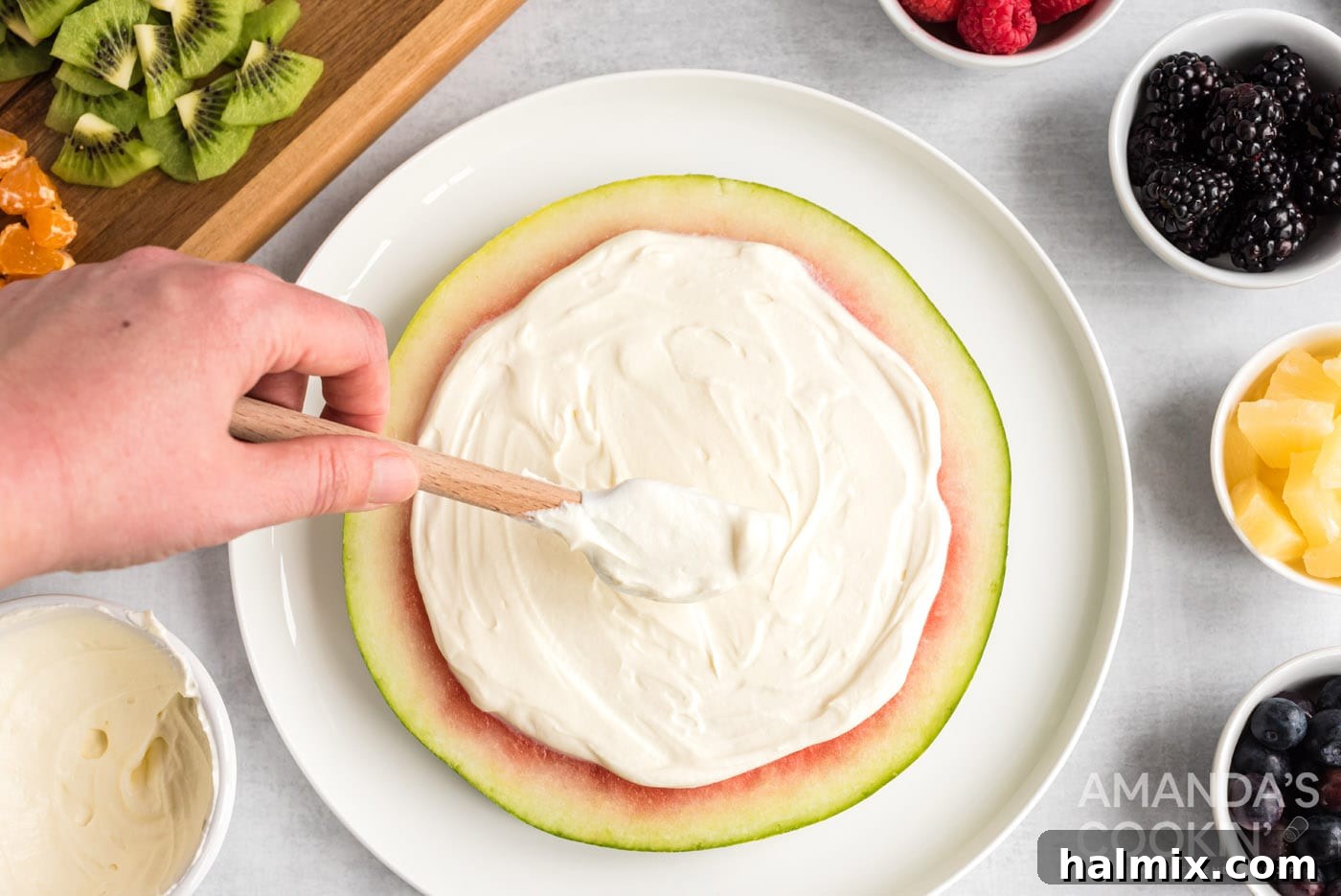 Crimson Crust Pizza 10 rubber spatula spreading cream cheese and yogurt mixture over a watermelon slice