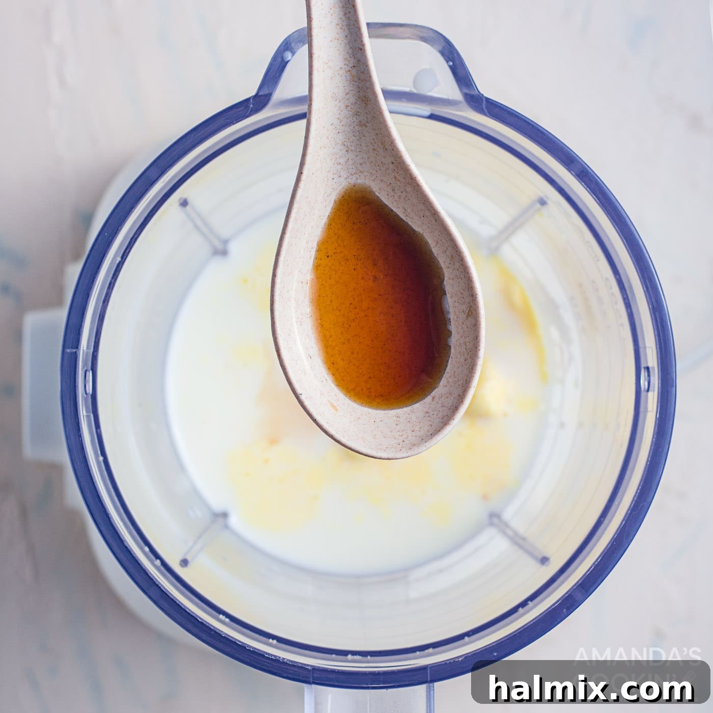 Close-up of salted caramel sauce being drizzled over a blender, ready to be added to the milkshake