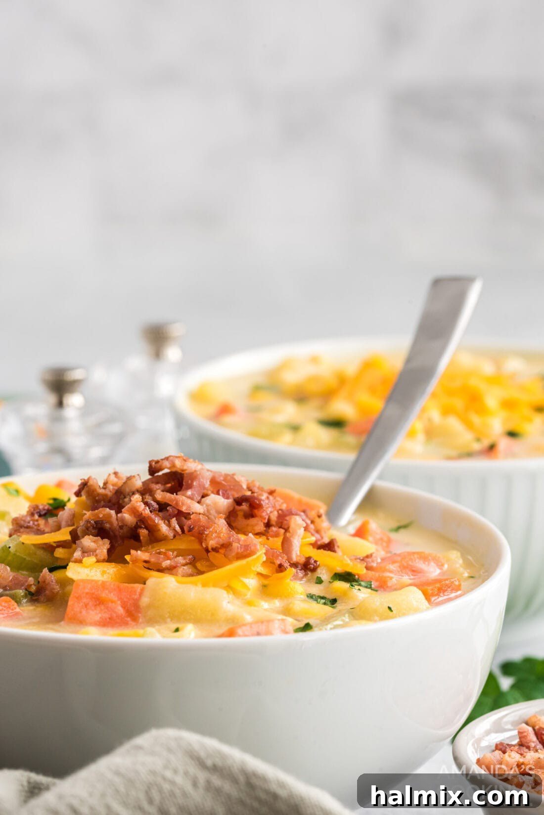 Sweet Corn Comfort 3 Close-up of a bowl of corn chowder soup with a spoon resting in it