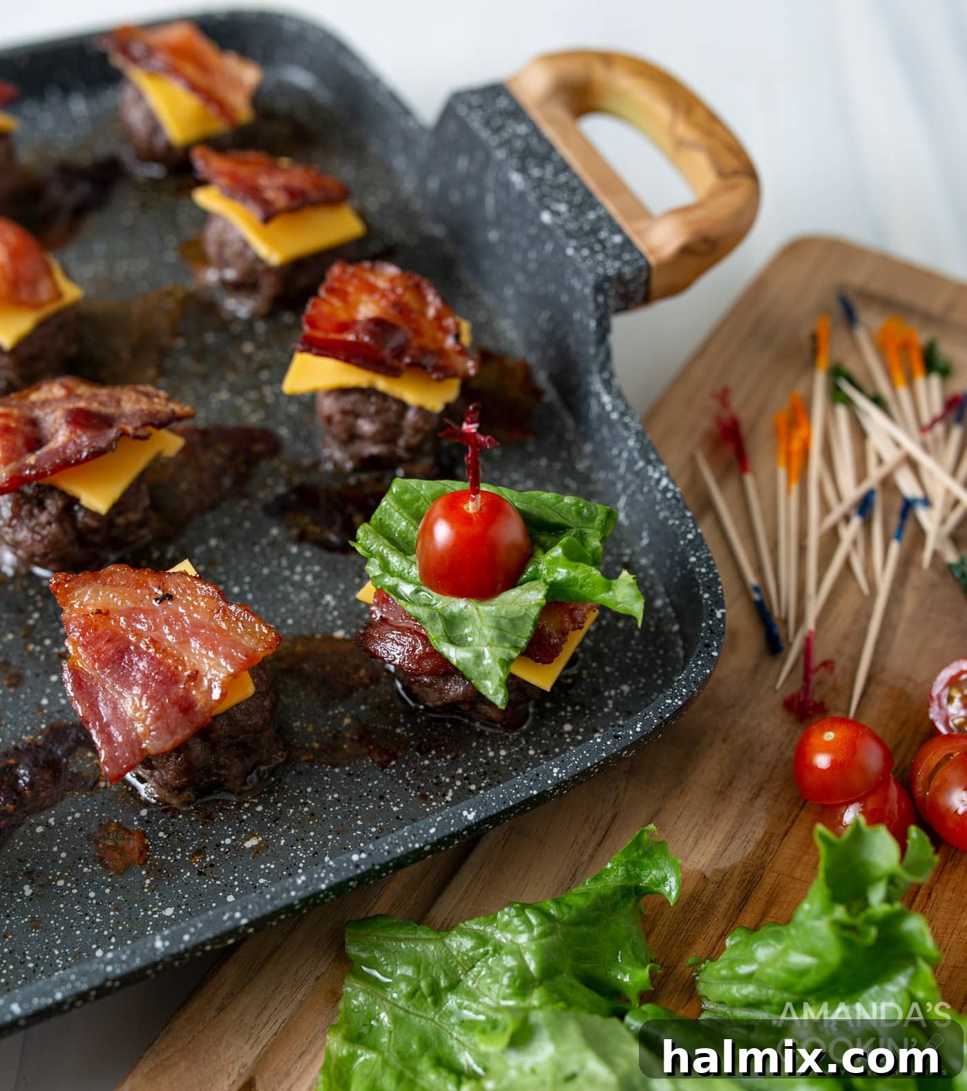 Bacon Cheeseburger Bombs 9 A close-up view of assembling bacon cheeseburger meatballs, layering the ingredients meticulously onto each toothpick.