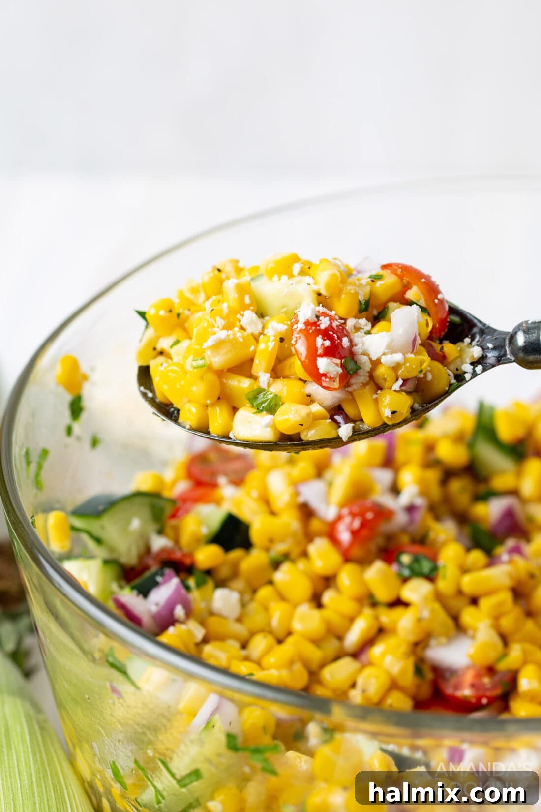 Sunshine Corn Salad 3 A spoonful of vibrant corn salad being served, highlighting the fresh and colorful ingredients like corn kernels, cherry tomatoes, and feta cheese.