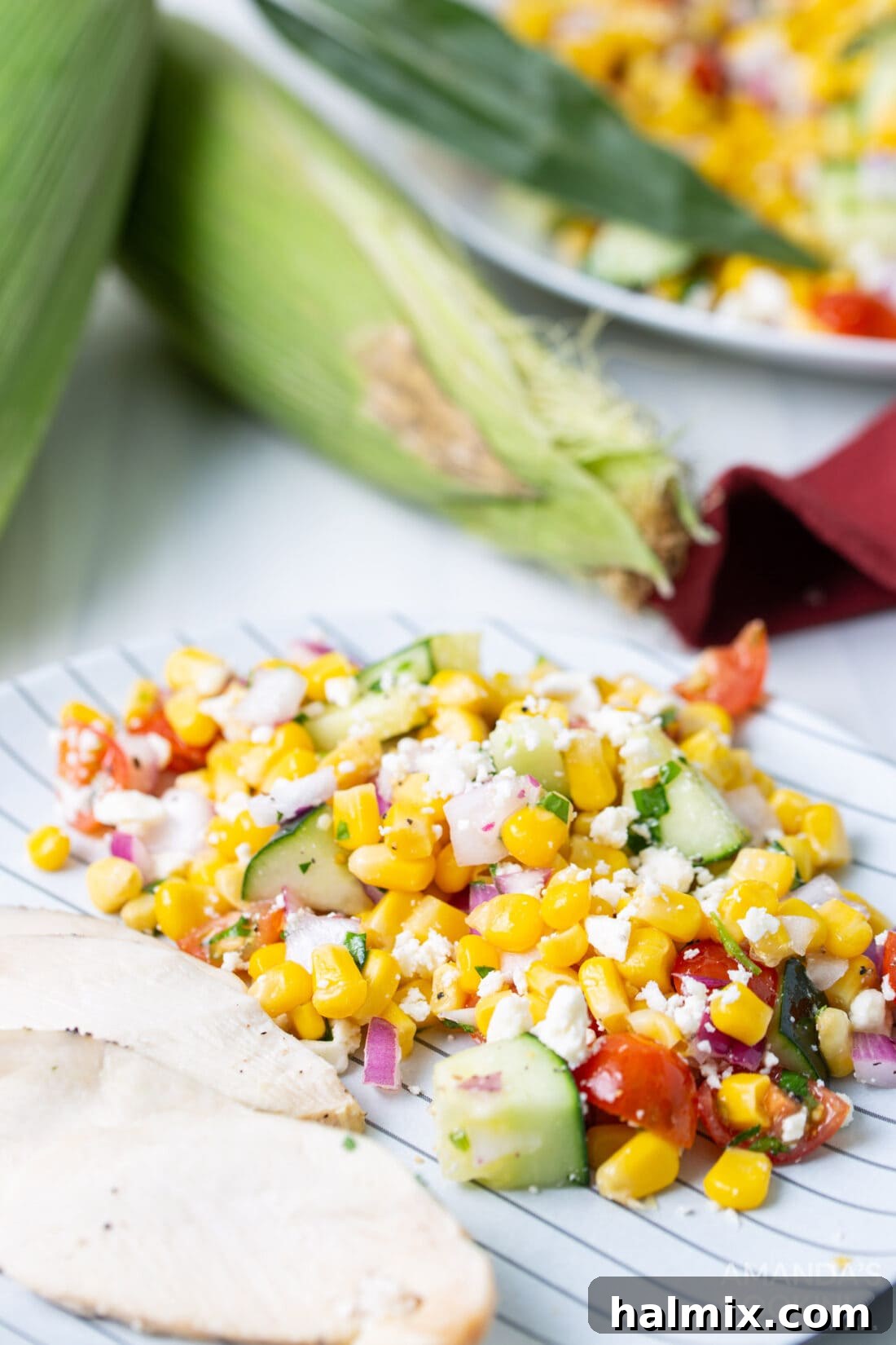 Sunshine Corn Salad 8 A serving of vibrant corn salad sitting alongside a main course, showcasing its appeal as a versatile and colorful side dish.