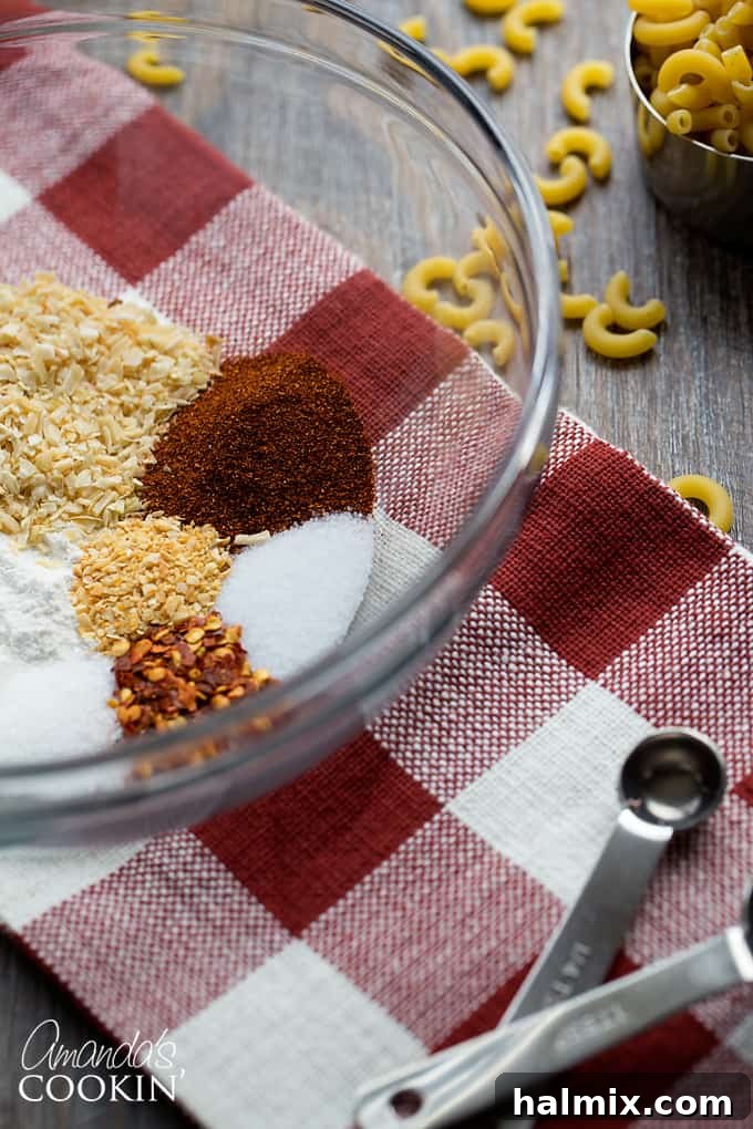 Chili Mac is a delicious combination of ground beef, beans, tomatoes, chili seasoning, and macaroni. This chili mac recipe makes a hearty dinner or a delicious cup of warmth for friends watching football! #chilimac #chili #groundbeef #beans #macaroni #footballrecipes #comfortfood #winterfood #chili An array of spices and seasonings arranged in small bowls, ready to be combined for the homemade chili seasoning mix.