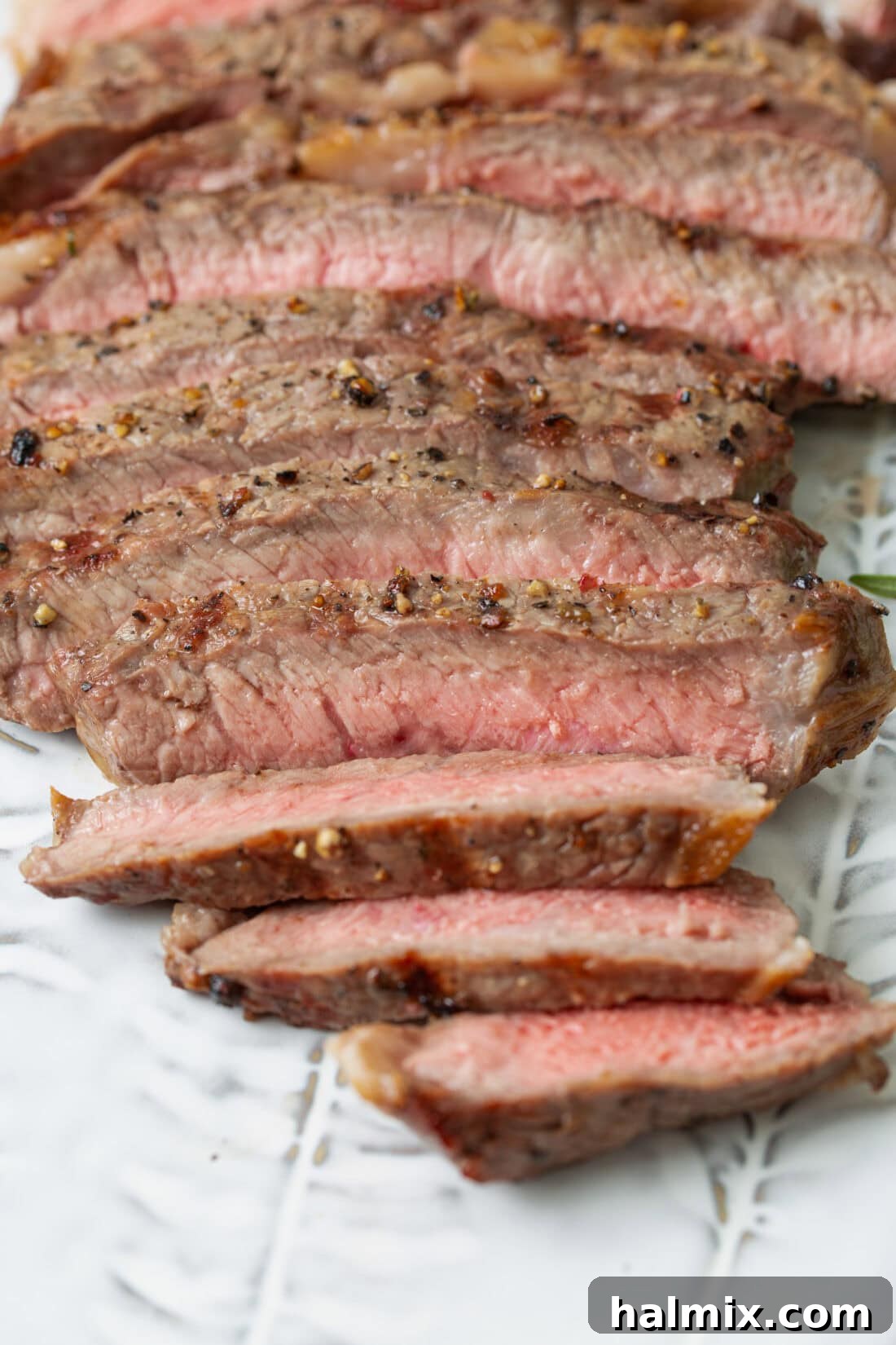 Perfectly sliced grilled steak, showcasing its juicy interior and crispy, flavorful sear