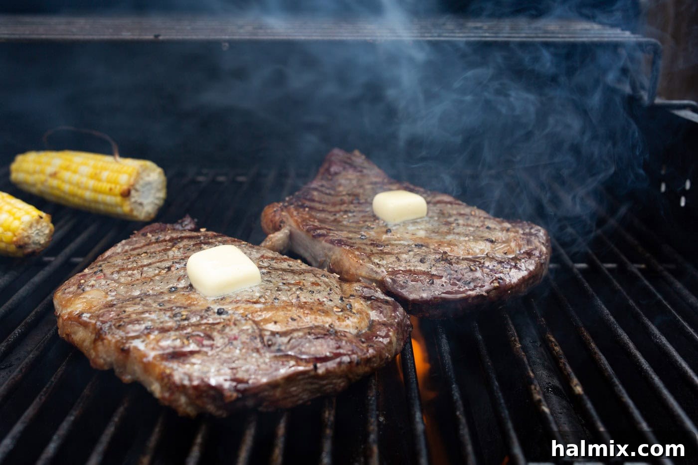 Pats of butter melting deliciously on grilled New York strip steaks, infusing them with extra flavor