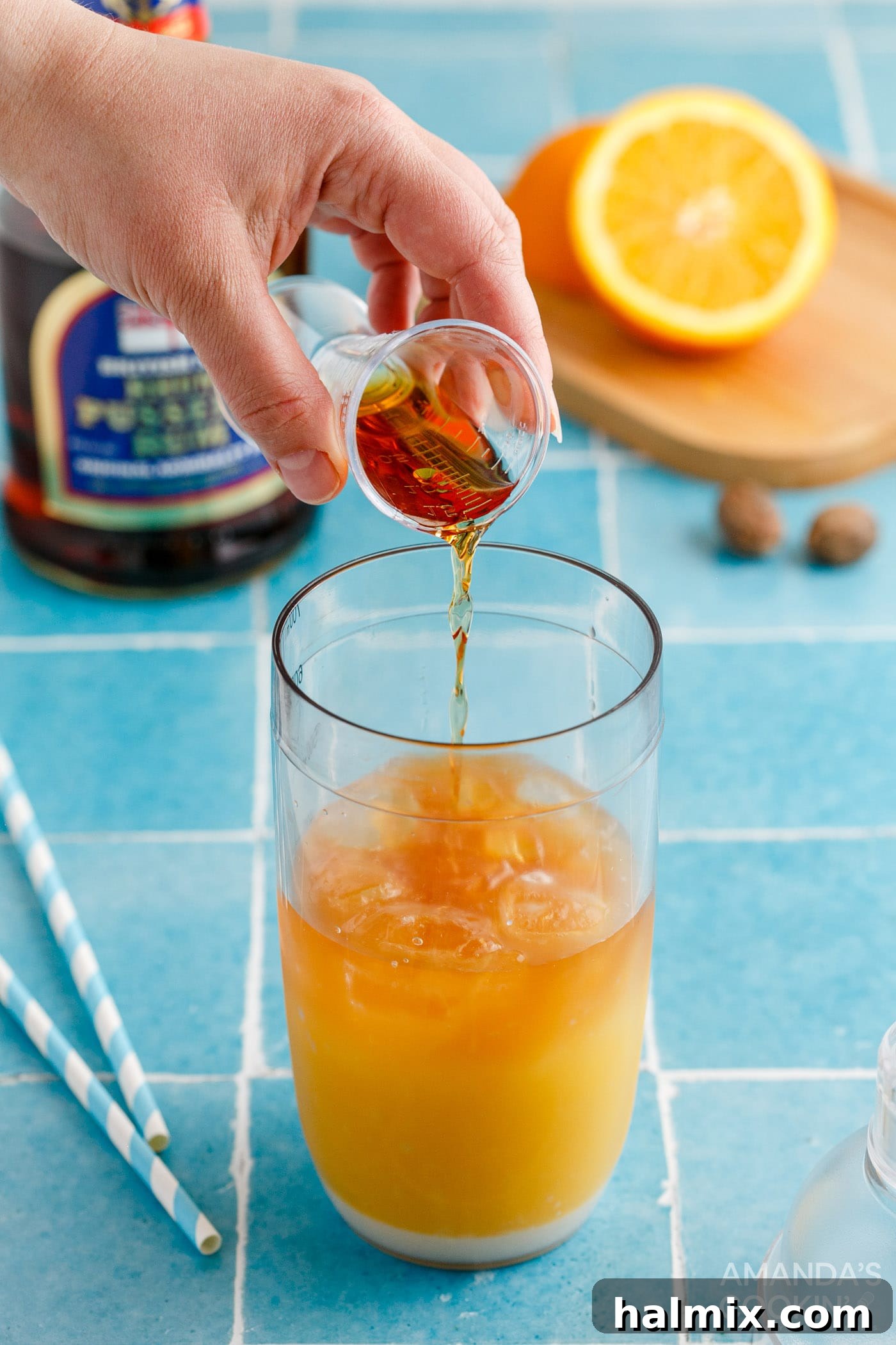 Adding ice, juices, cream of coconut, and rum to a cocktail shaker for Painkiller