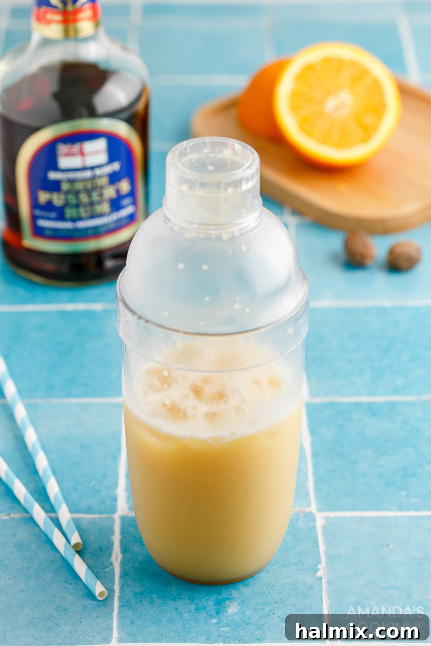 Shaking a Painkiller Cocktail in a metal shaker until thoroughly chilled