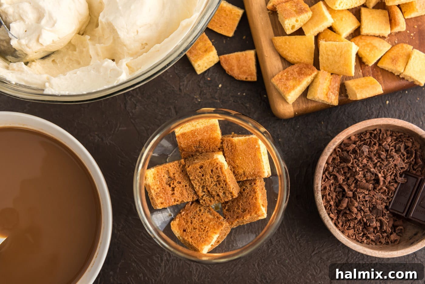 Cubed ladyfingers carefully arranged at the bottom of a parfait dish, ready for the next layer.