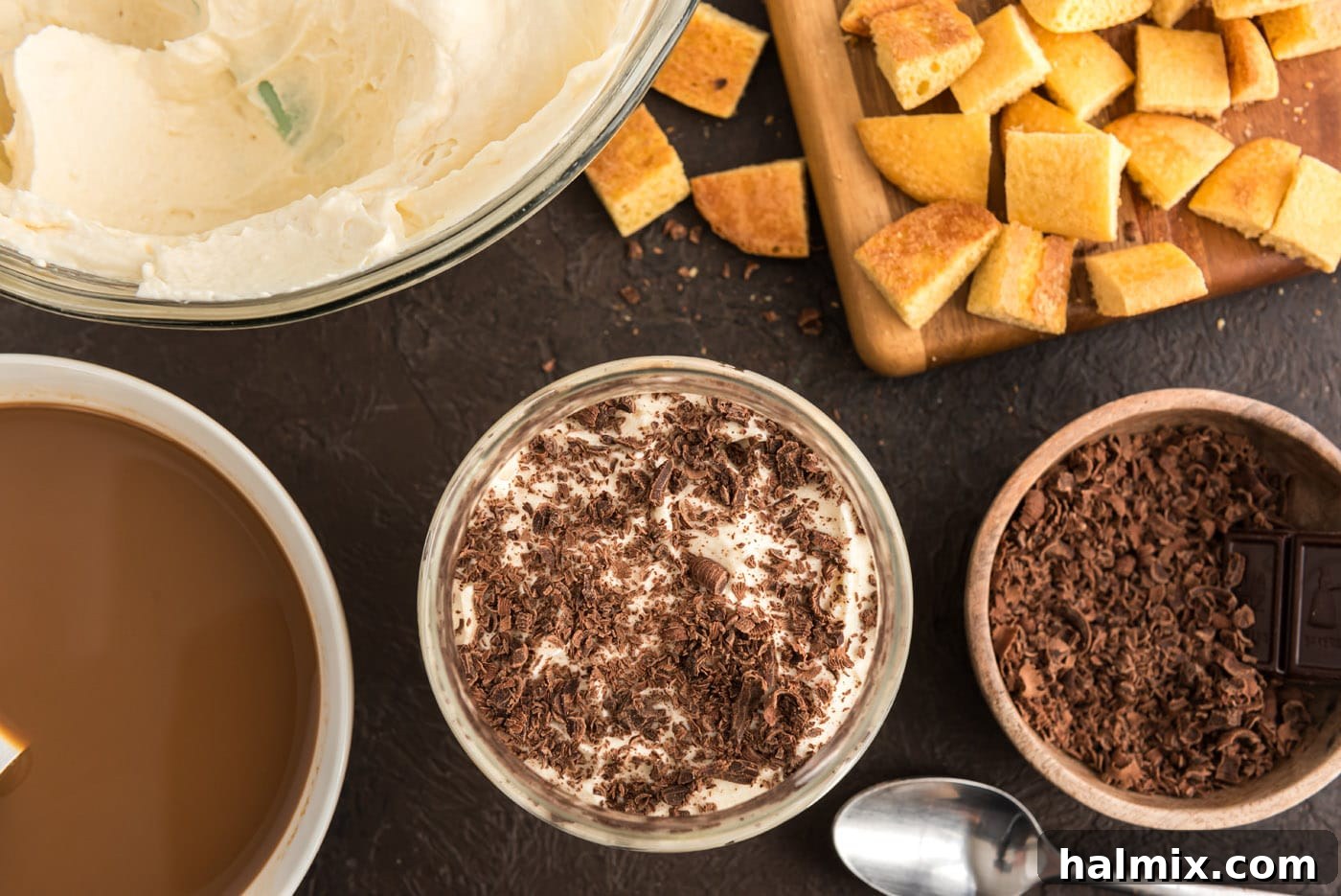 Delicate shaved chocolate sprinkled on top of the first layer of creamy Bailey's Tiramisu in a parfait glass.