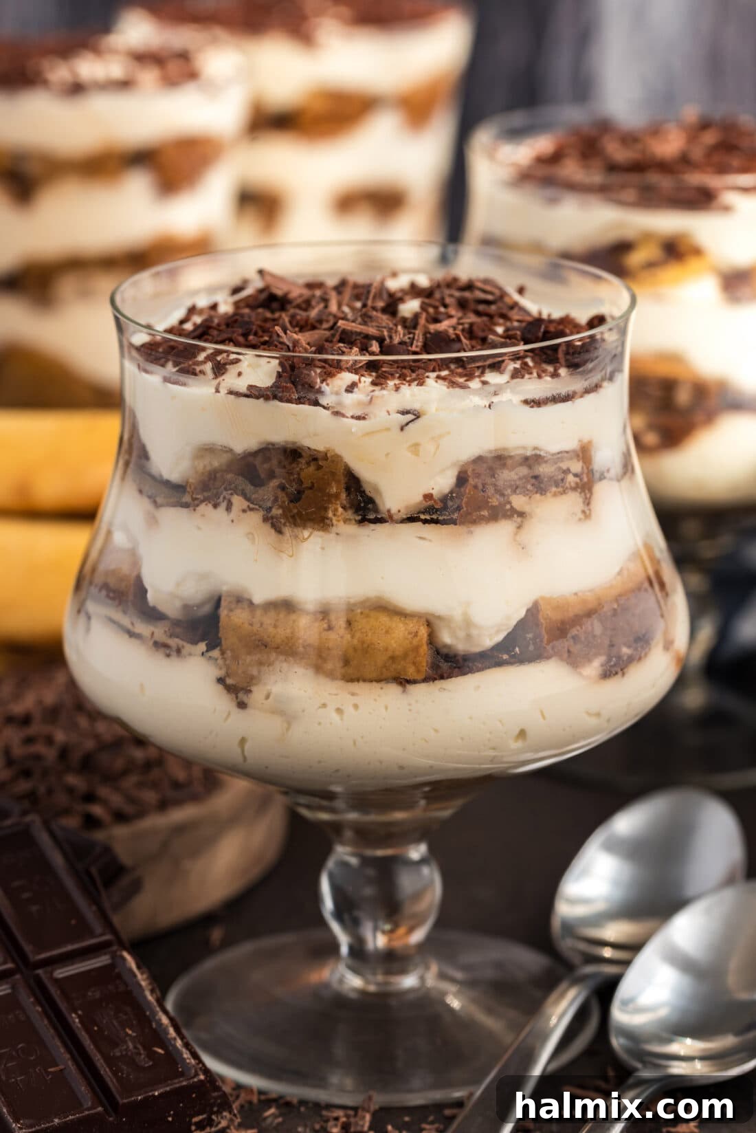 Several Bailey's Tiramisu Parfaits arranged on a tray, with one in the foreground showcasing its distinct layers.