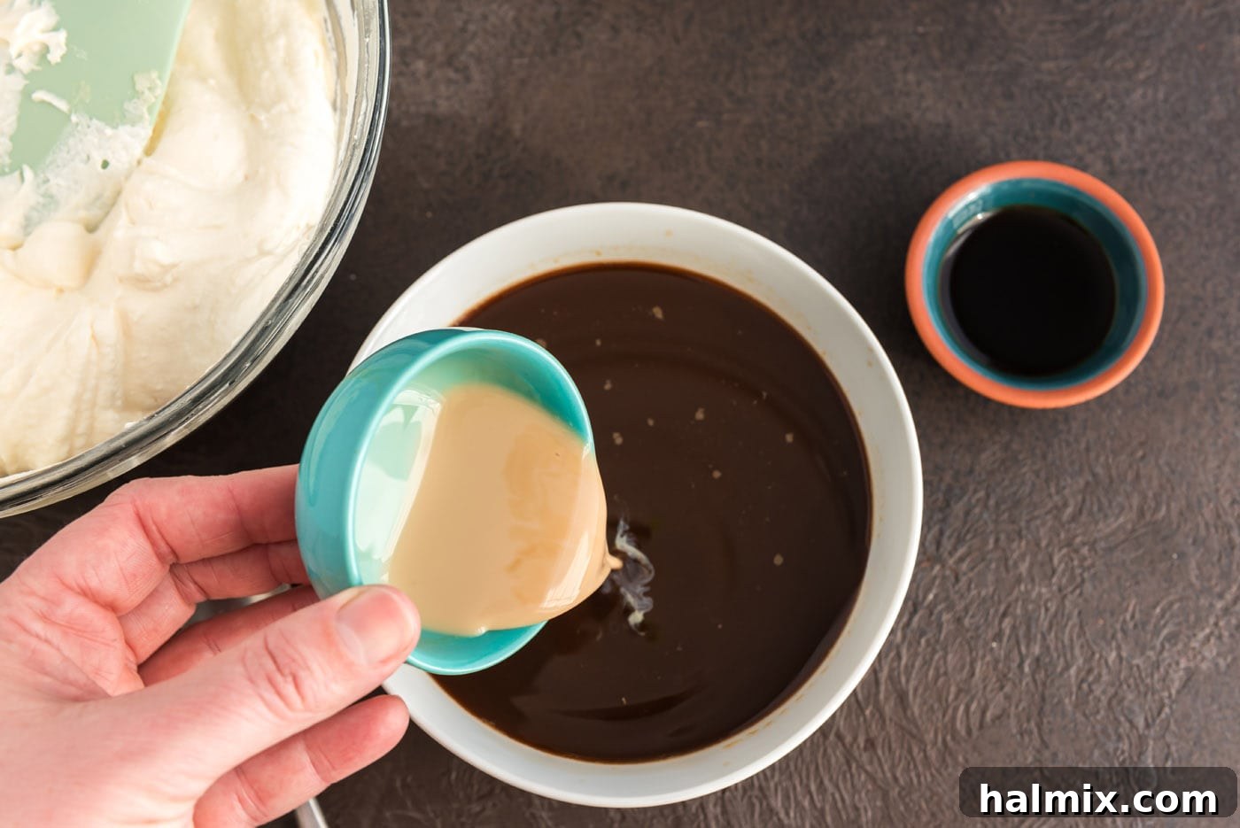 Bailey's Irish Cream being poured into a cup of cooled espresso, preparing the dipping mixture for ladyfingers.