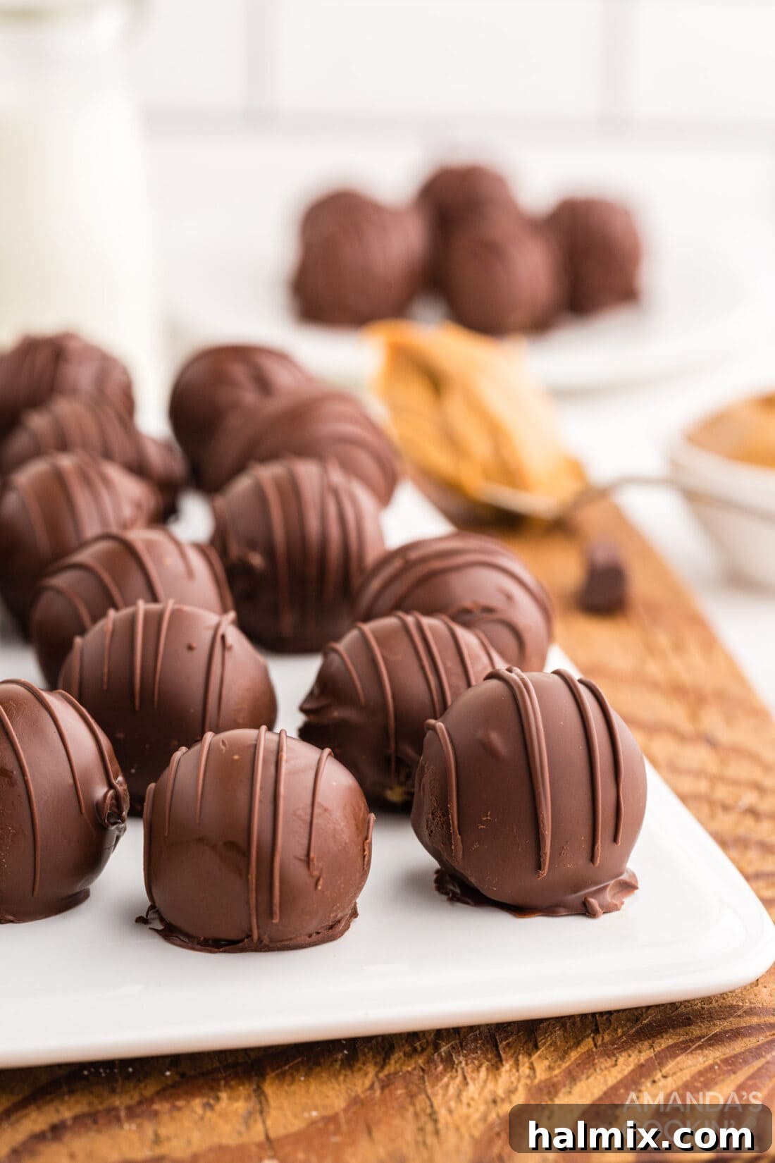 A elegant white cutting board presenting a cluster of perfectly coated chocolate peanut butter balls, ready to be enjoyed.