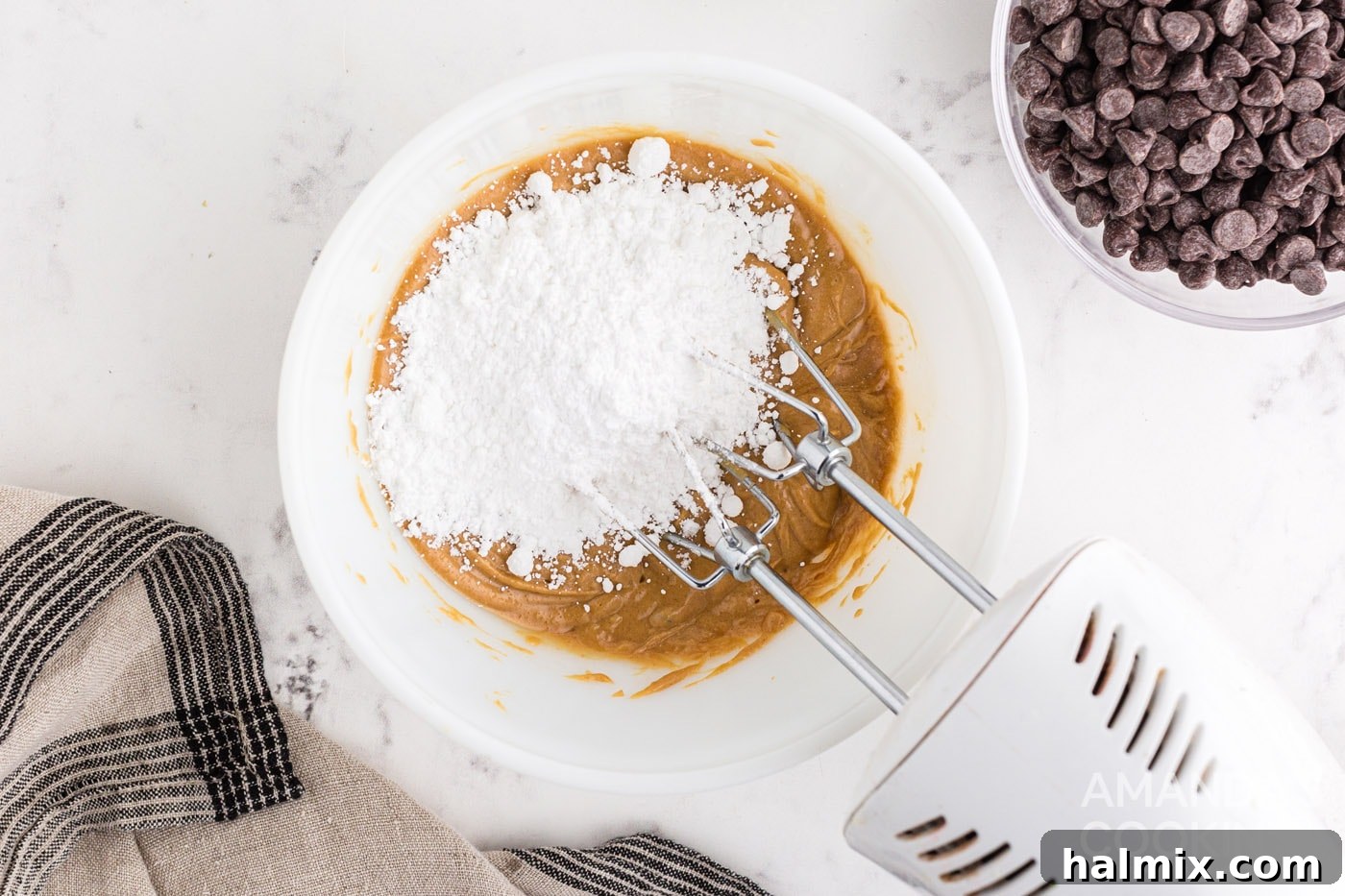 Powdered sugar being mixed into the peanut butter mixture, creating a crumbly consistency.