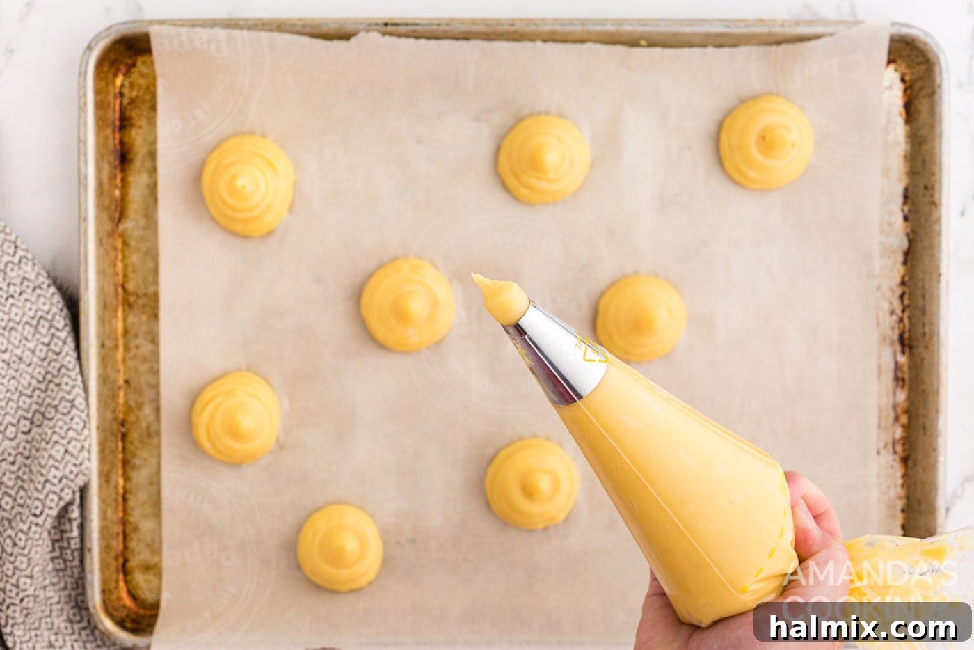 Puffy Cream Delights 9 piping choux pastry dough onto baking sheet