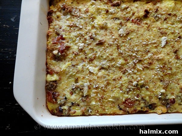 An overhead photo of a golden-brown herbed breakfast stuffing casserole, fresh from the oven and ready to serve.