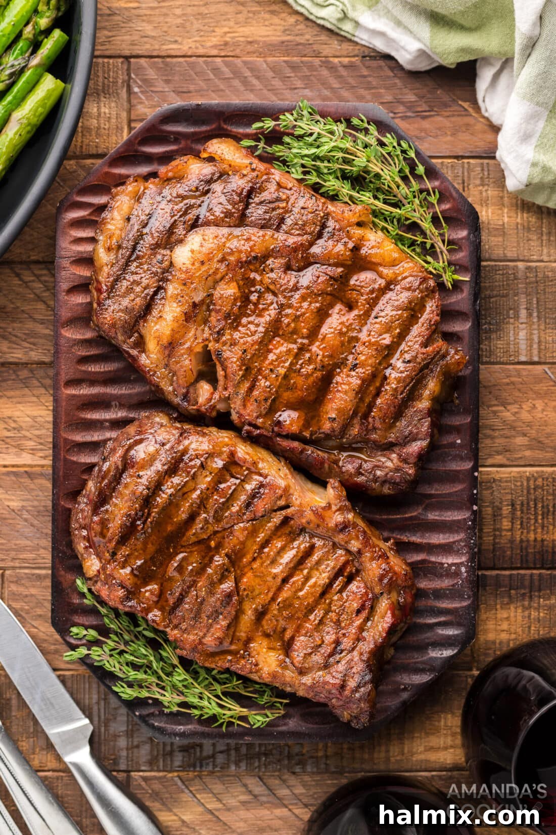 2 Smoked Ribeye steaks on cutting board, perfectly cooked and ready to be sliced.