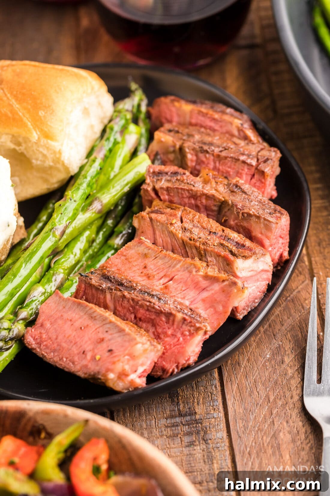 Perfectly sliced smoked ribeye steak on a plate, showcasing its tender, pink interior and flavorful crust.