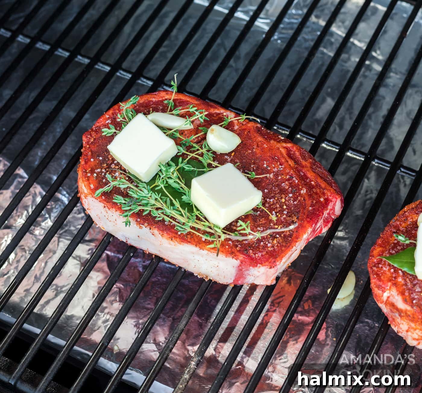 Ribeye steak smoking on the grill grates of a smoker.