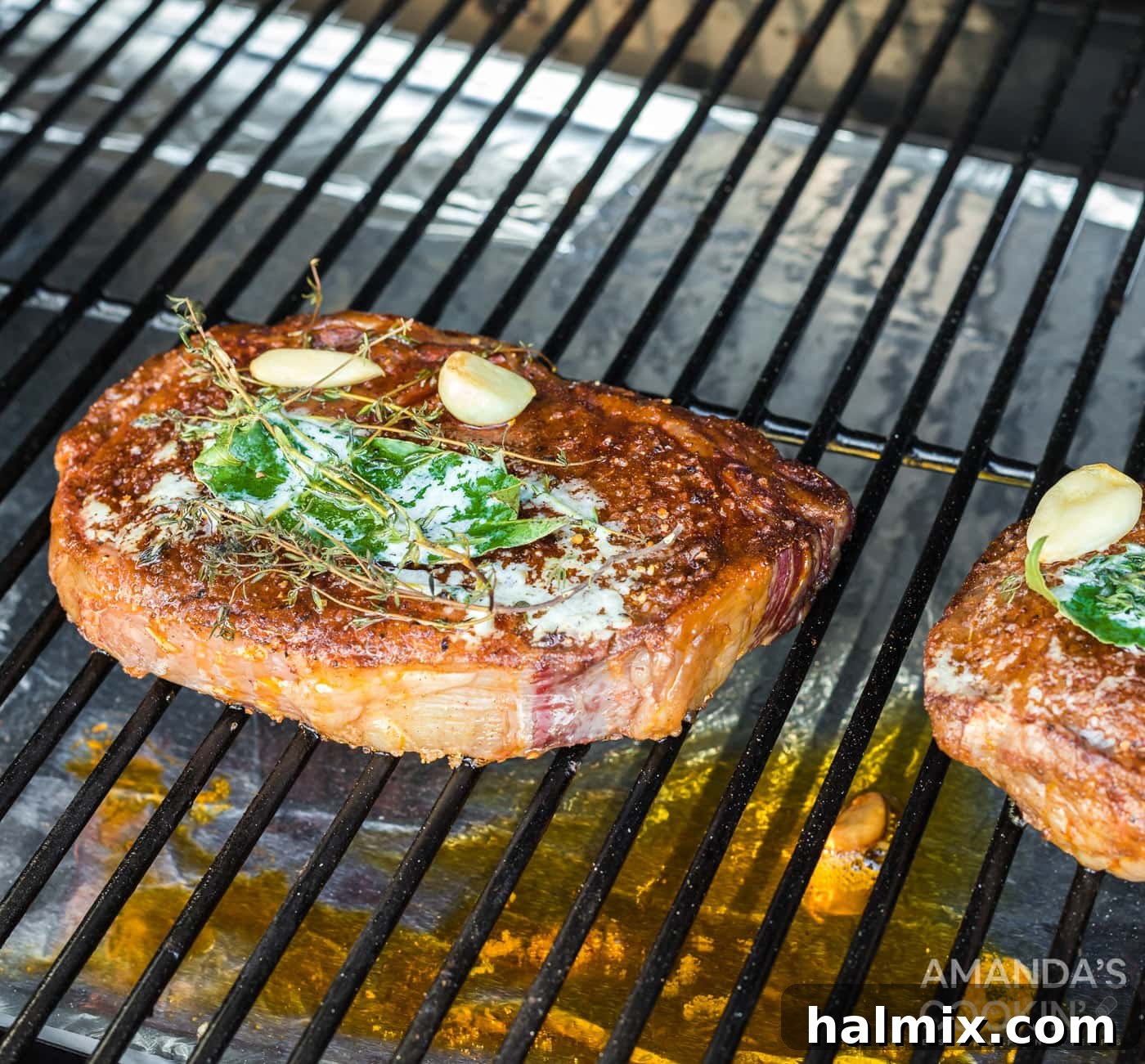 Smoked ribeye steaks resting on a grill after being removed from the smoker.